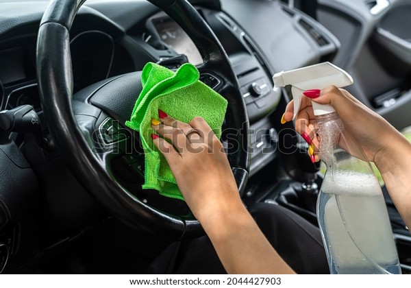 female hand cleaning console car with microfiber cloth,\
close up 