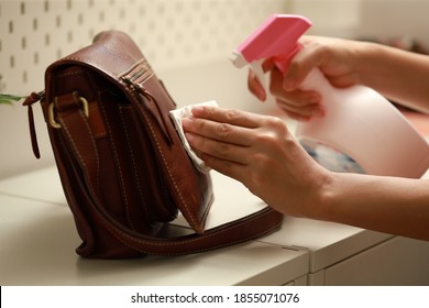 Female Hand Cleaning The Surface Of The Leather Bag. Coronavirus Prevention, Hygiene To Stop Spreading Coronavirus.