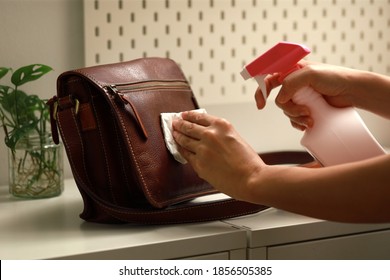 Female Hand Cleaning The Surface Of The Leather Bag. Coronavirus Prevention, Hygiene To Stop Spreading Coronavirus.