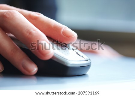 female hand clicking computer mouse