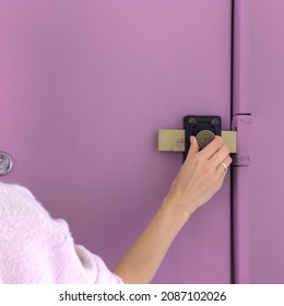 Female hand closing the door lock from the inside. Matt purple door with an oldschool, vintage lock.