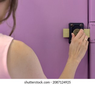 Female hand closing the door lock from the inside. Matt purple door with an oldschool, vintage lock.