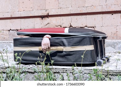 Female Hand Coming Out Of A Suitcase. Imitation Of The Murder Of A Woman By A Maniac Or Serial Killer.