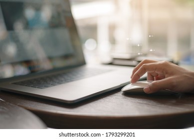 Female hand with computer mouse on table, hand using mouse and laptop computer in modern office with virtual screen interface icons diagram as concept. - Shutterstock ID 1793299201