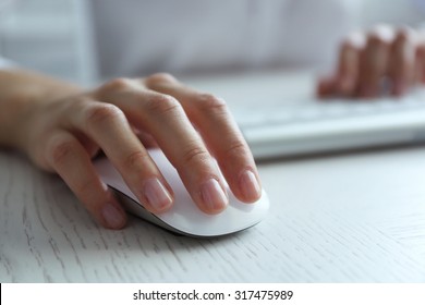 Female hand with computer mouse on table, closeup