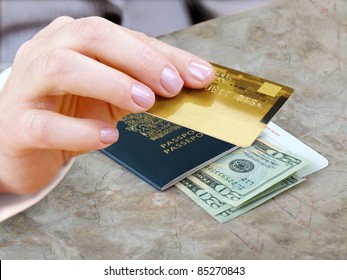 Female Hand With Credit Card And Passport, Dollars Bills On The Table.