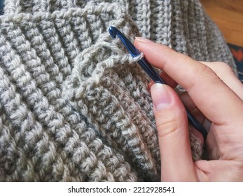 Female hand with crochet hook making gray woolen winter scarf collar, crocheting antistress therapy, hygge concept. English rib stitch with a single crochet - Powered by Shutterstock