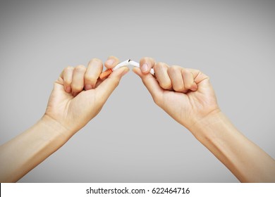 Female Hand Crushing Cigarette Isolated On Grey Background.World No Tobacco Day-Quitting Smoking Concept.