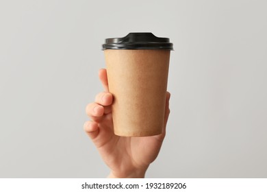 Female Hand With Cup Of Coffee On Grey Background