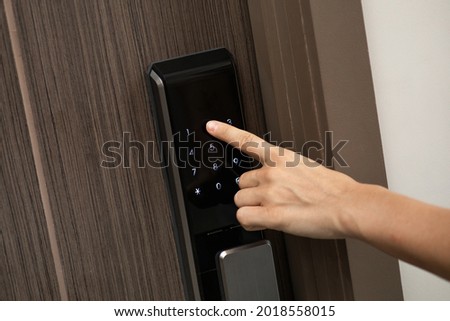 Female hand and digital smart code lock into the modern apartment