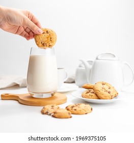 Female Hand Dips Cookies In Milk