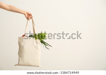 Female hand with eco bag on white background. Zero waste concept