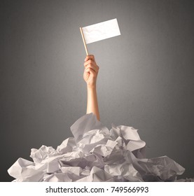 Female Hand Emerging From Crumpled Paper Pile Holding A White Blank Flag 