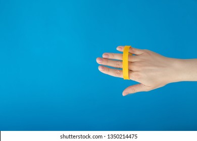 Female Hand With Empty Yellow Bracelet On Blue Background. Music Festival Branding Empty Wristband Design. Clear Sweat Band Mock Up Design.