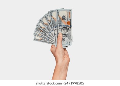 Female hand with fan of dollar banknotes, gray background. Concept of payments. - Powered by Shutterstock