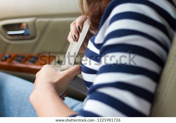 Female hand fastening a seat belt in the car, Safety\
first concept. 