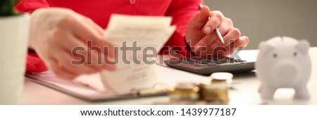Female hand financial inspector push key butoon on gray calculator. Makes calculation costs turning over in hands paper checks for month. Family budget planning concept.