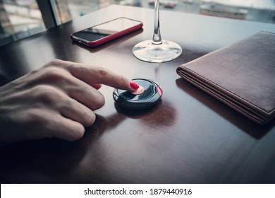 Female Hand Finger Presses The Button To Call The Waiter In The Restaurant To Pay For Food For Dinner. Pressing The Buzzer. Good Tips.