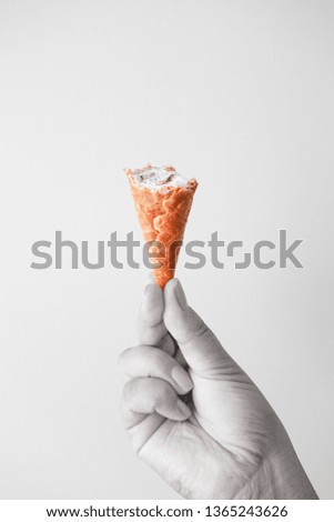 Female hand fingers hold a waffle cone with ice cream, black and white collage. Summer concept