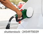 Female hand fueling car with gasoline. Hand filling car with gasoline. Gas station attendant fueling car.
