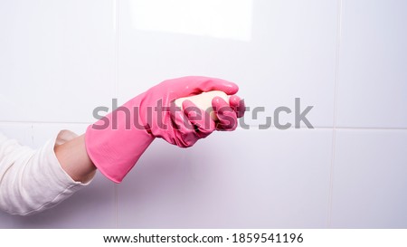 female hand in a glove holds soap