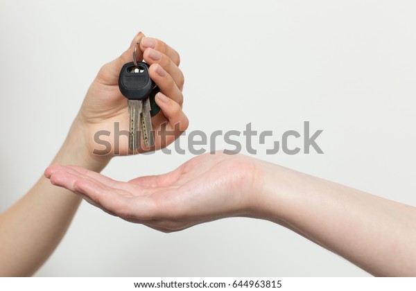 Female hand hands over the keys to the castle\
apartment the other a female\
hand