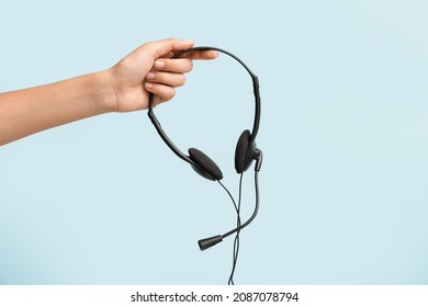 Female hand with headset on color background