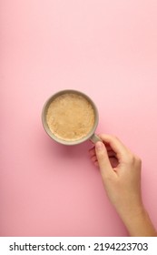 Female hand hold coffee cup on pink background. Top view - Shutterstock ID 2194223703