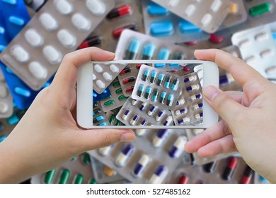 Female hand hold mobile smart phone taking photo of medicine pills