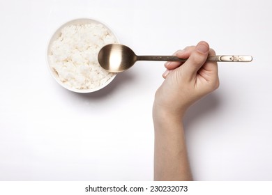 A Female Hand Hold Rice With Spoon Isolated White, Top View At The Studio.