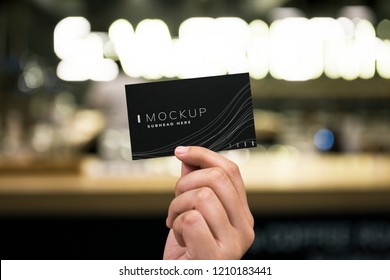 Female hand holding a black business card mockup