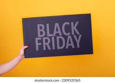 Female hand holding a black friday poster.