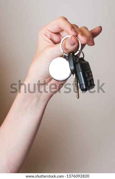 female hand holding car key\
chain