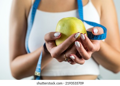 Female Hand Holding Centimeter Tape And Apple Fruit.Healthy Lifestyle Concept. Concept Of Natural Organic Food