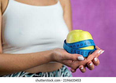 Female Hand Holding Centimeter Tape And Apple Fruit.Healthy Lifestyle Concept. Concept Of Natural Organic Food