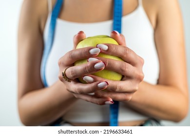 Female Hand Holding Centimeter Tape And Apple Fruit.Healthy Lifestyle Concept. Concept Of Natural Organic Food