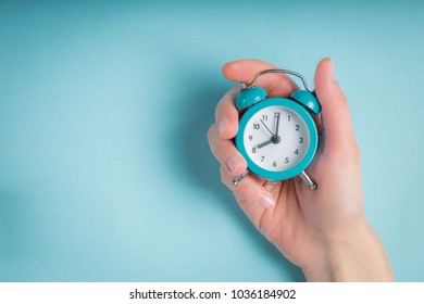 Female Hand Holding Clock