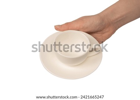 Female hand holding coffee cup and saucer isolated on a white background. 