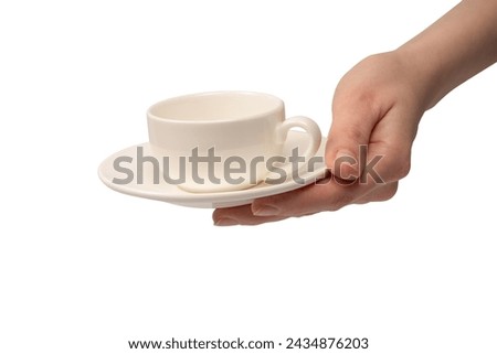 Female hand holding coffee cup and saucer isolated on a white background. 