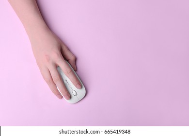 Female Hand Holding Computer Mouse On Pink Background