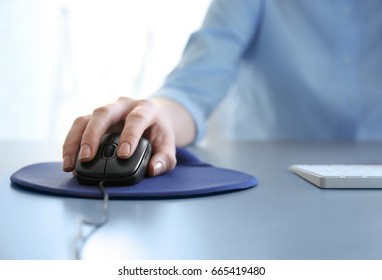 Female Hand Holding Computer Mouse On Pad