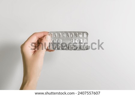 female hand holding an empty blister of pills