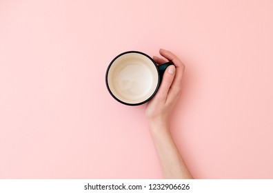 Female Hand Holding Empty Mug On Pink Background. Flat Lay, Top View, Overhead