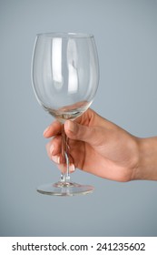 Female Hand Holding An Empty Wine Glass.