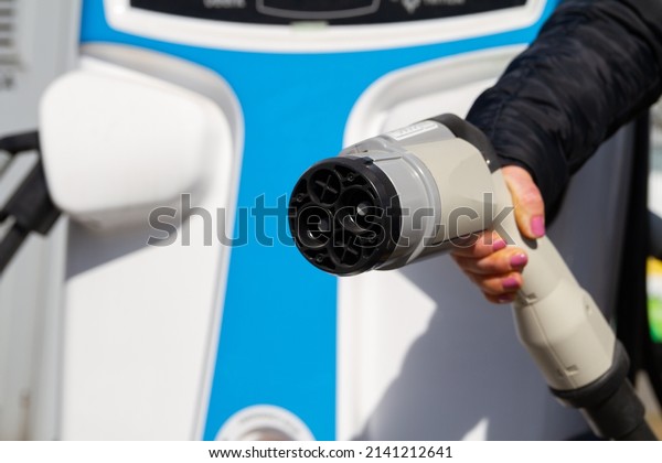 Female hand holding fast charging socket\
CHAdeMO. Connector plug for electric vehicles battery at EV car\
charging station, direct current\
DC.