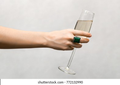 Female Hand Holding A Glass Of Champagne Isolated On White Background.