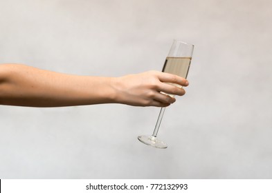 Female Hand Holding A Glass Of Champagne Isolated On White Background.