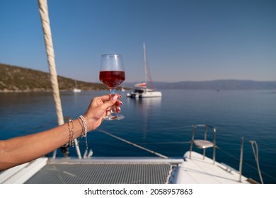 Female Hand Holding Glass Of Wine On Sea Background