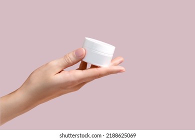 Female hand holding jar of cosmetic cream on pastel pink background. Cosmetic beauty product branding mockup. Copy space. Mockup. High quality photo - Powered by Shutterstock