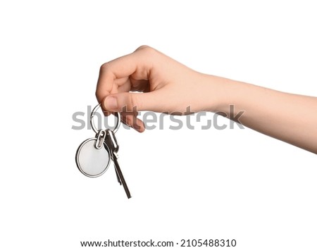 Female hand holding keys with round keychain on white background
